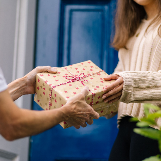 Man giving a women a gift box that's been gift wrapped